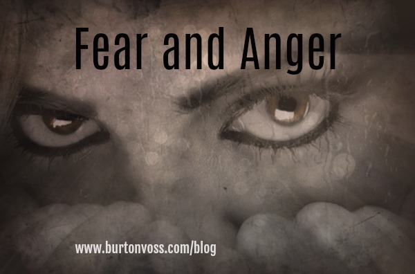 Close up of female eyes with knuckles clenched near nose. 