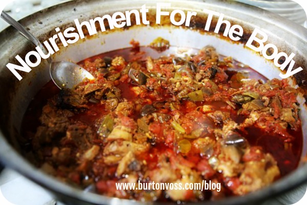 A bowl of beef stew swimming in tomato sauce.